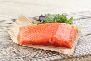 Raw salmon fillet over board