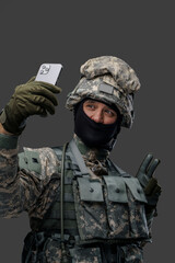 Shot of glad serviceman from ukraine dressed in protective uniform taking selfie. Information warfare.