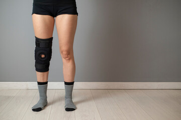 Description: Knee Support Brace on leg isolated on white background. Elastic orthopedic orthosis. Anatomic braces for knee fixation, injuries and pain. 