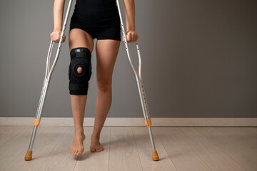 Closeup of a womans legs with one knee in a protective knee brace