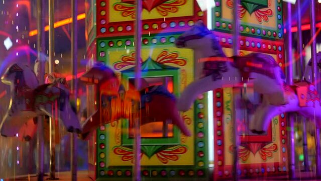 Horses going around a carousel in an amusement arcade at a fairground carnival