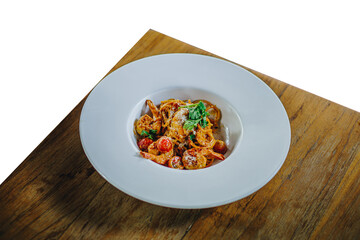 Shrimp cream sauce spaghetti in a large white plate on a wooden table on a white background.