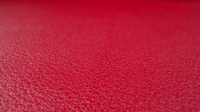 Abstract pattern of wrinkles on red cow leather surface as background macro view. Sewing material for different items crafting. Design and decor