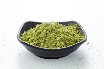 Matcha green tea powder in a black dish