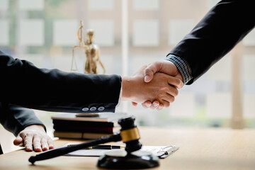 Fototapeta na wymiar Lawyers shake hands with clients who come to testify in the case of embezzlement from business partners who jointly invest in the business. The concept of hiring a lawyer for legal proceedings.