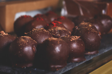 Cheese candies in chocolate coating on counter.