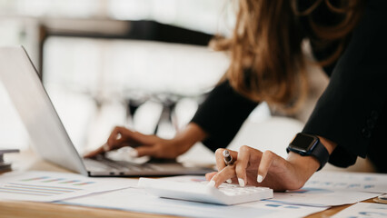 A beautiful Asian businesswoman sitting in her private office, she is checking company financial documents, she is a female executive of a startup company. Concept of financial management.