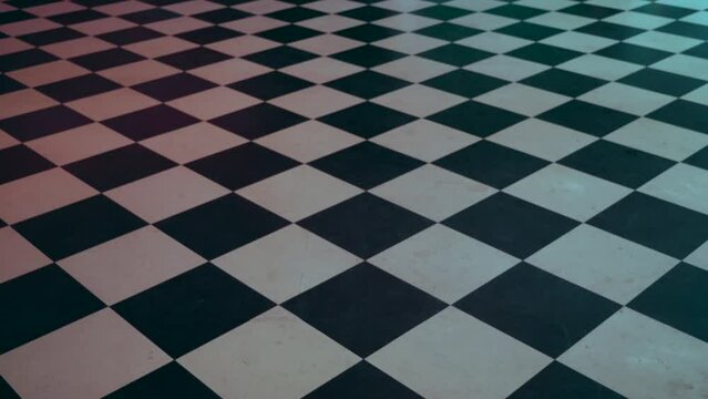 A checker floor in a diner. The checkered flooring tiles are black and white