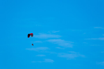 Patterned paraglide flying against the background of a blue sky. Photo taken in fine weather, late...