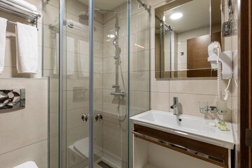 Interior of a hotel bathroom with glass shower cabin
