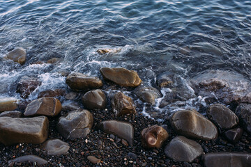  Seashore with pebbles and stones in the evening at sunset