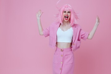 Young positive woman in a pink suit gesturing with his hands emotions fun color background unaltered