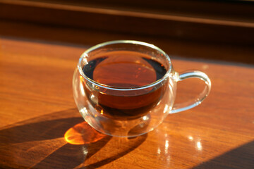 Cup of tea stands on wooden windowsill