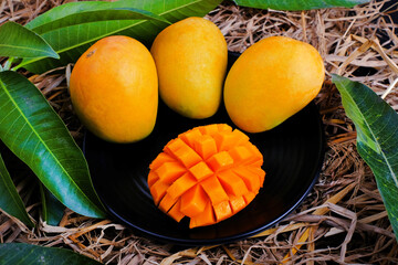 Mango tropical fruit with green leaf, Ripe mango in grass closeup