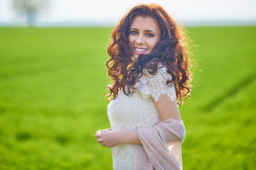 portrait of a beautiful woman on a green field on a spring day