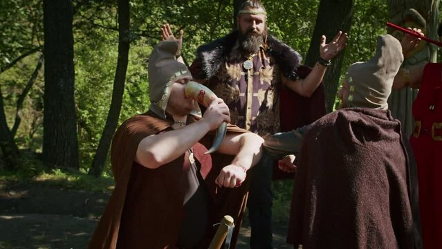 mystical fraternal rite on the blood of two warriors. the priestess and the shaman supervise the execution process.