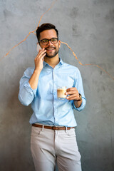 Portrait of successful businessman talking on smartphone in coffee break in office