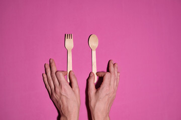 Wooden spoon, fork, paper cups gray background. Disposable tableware made of natural materials. The concept of a zero waste, sustainable lifestyle. Eco-friendly disposable tableware