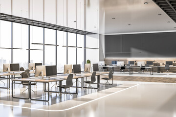 airy modern open space office with eco style interior design, laptops on wooden workspace tables, black chairs, illuminated floor decoration huge glass wall as a window and blank black wall.