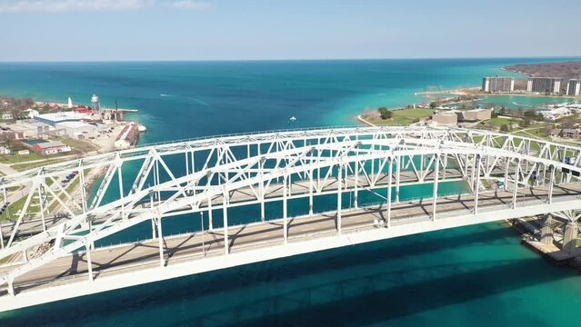 Blue Water Bridge connecting Port Huron, Michigan USA and Sarnia, Ontario Canada with drone moving down.
