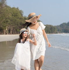 Fototapeta na wymiar Asian Family walking at beach with kids happy vacation concept
