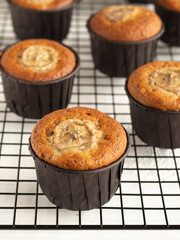 Banana cupcakes in the brown paper baking forms on the cooling rack, close up