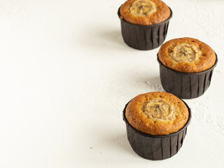 Banana cupcakes in the brown paper baking forms, high key, close up, copy space
