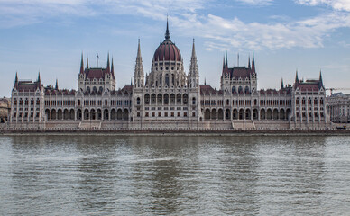 Fototapeta na wymiar The Hungarian Parliament Building in the old town of Budapest, Hungary, Eastern Europe. Detail of the historical limestone facade and the towers of the iconic Hungarian landmark.