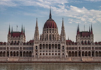 Fototapeta premium The Hungarian Parliament Building in the old town of Budapest, Hungary, Eastern Europe. Detail of the historical limestone facade and the towers of the iconic Hungarian landmark.