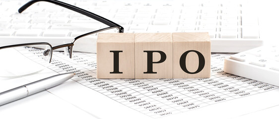 IPO written on wooden cube with keyboard , calculator, chart,glasses.Business concept