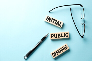 Text IPO abbreviation of Initial Public Offering concept on wooden block on the blue background