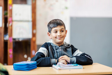 Naklejka premium Portrait of clever Rome schoolboy following lecture in the classroom.