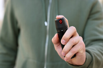 Man using pepper spray, closeup. Space for text