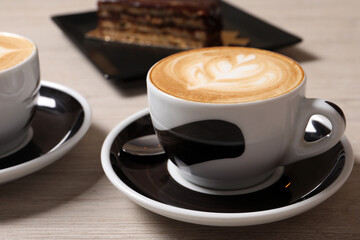 Cups of aromatic coffee on wooden table, closeup