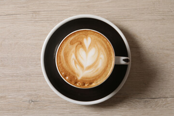 Cup of aromatic coffee on wooden table, top view