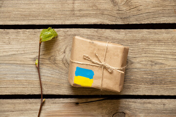 A box with a painted yellow-blue flag of Ukraine on a wooden table, humanitarian aid for Ukraine,...