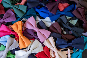 Colorful bow ties texture, pile of bow ties spilled on the floor, top view neck tie backdrop, lay...