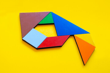 Colorful number nine made with tangram toy, colored tangram number 9 isolated on yellow background,...