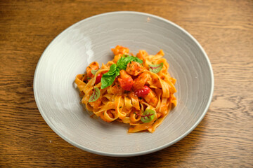 and fresh basil in a plate on a white wooden background. Selective focus.