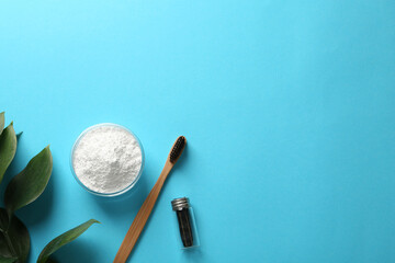 Bowl of tooth powder, brush, dental floss and plant on turquoise background, flat lay. Space for...
