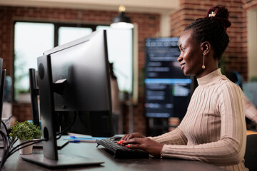 Confident african american network developer engineering application for company database. Cyber security team member developing advanced firewall system in order to protect encrypted files.