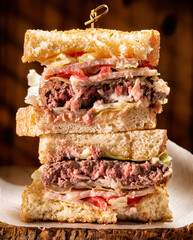 Chopped beef steak, bacon, lettuce and tomato (BLT) sandwich.