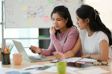 Two female college students doing homework in the co-working space