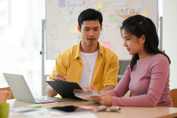 Male and female marketing workers working and planning the project together