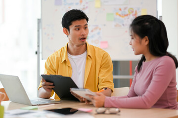 Obraz premium Male officer talking with female coworker in the office workplace.