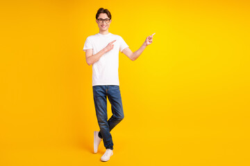 Fototapeta na wymiar Full length photo of young cheerful guy indicate fingers empty space promotion ads isolated over yellow color background
