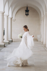 Fototapeta premium The bride in a flowing wedding dress. Castle wedding.