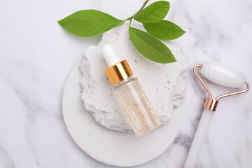 Cosmetic glass bottle with dropper and green leaves on podium. The concept of a beauty salon and natural cosmetics.