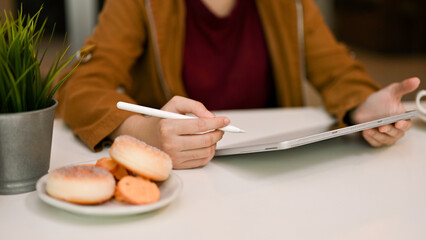Obraz na płótnie Canvas Female remote working at the cafe, using digital tablet