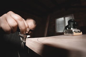 Carpenter with hand electric router machine at work. Trying on a cutter